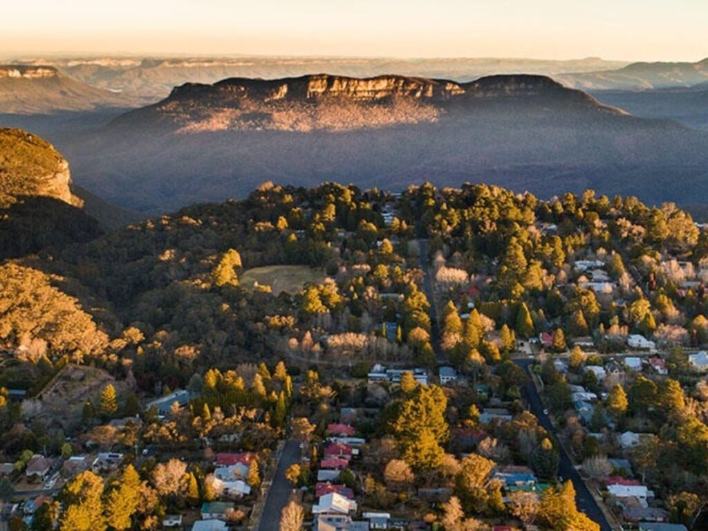A misty, low-angle view of the Pool of Siloam walking track in Leura, featuring ancient moss-covered rocks and a lush rainforest canopy in the Blue Mountains.

